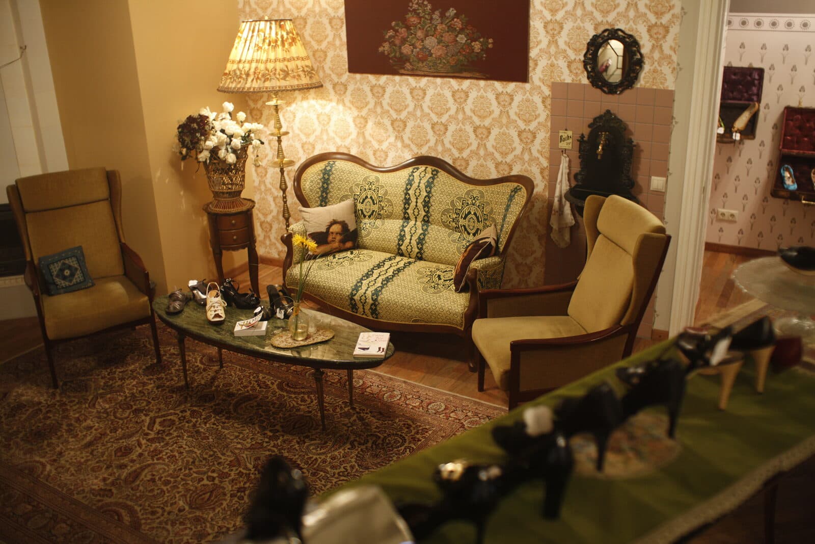 The Madam Bonbon salon — patterned wallpaper, antique sofas and shoes on show